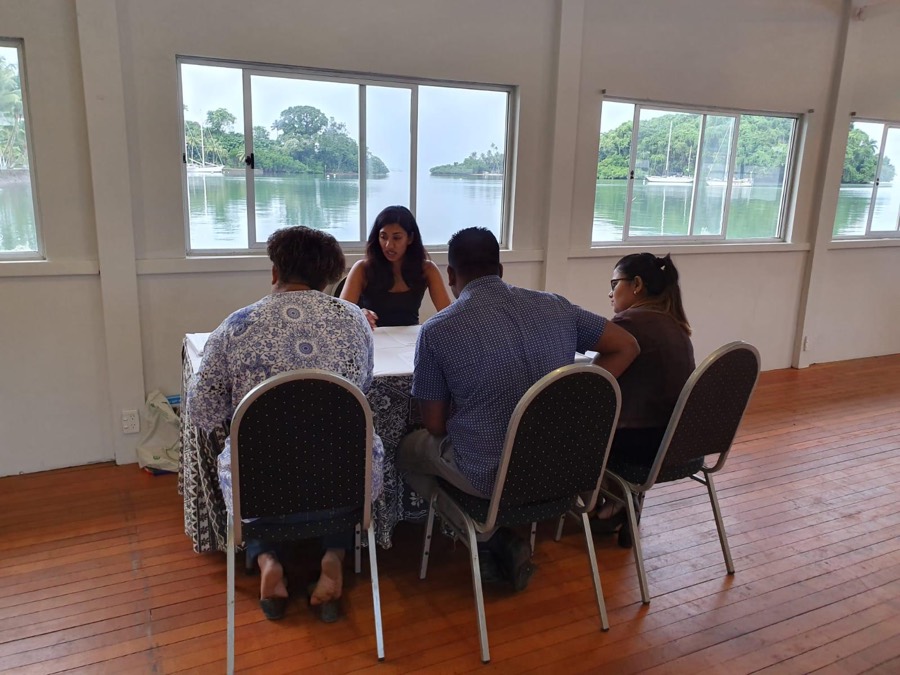 Shani talking a family through their options at a waterside consultation table in Fiji